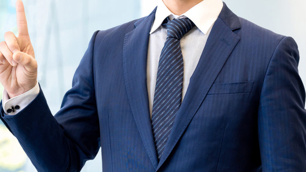 人差し指を上に指すビジネスマン