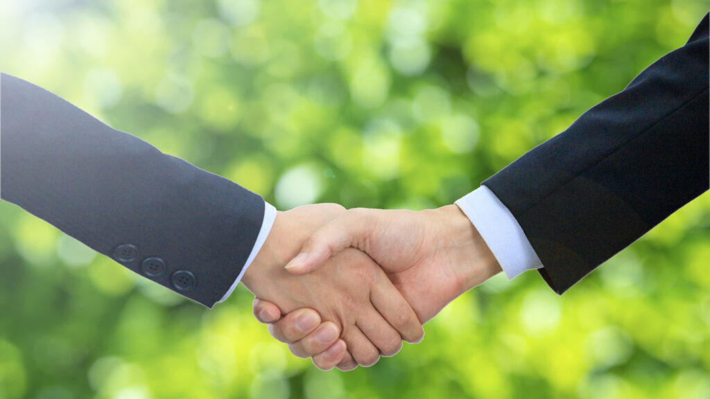 握手にグリーンの背景