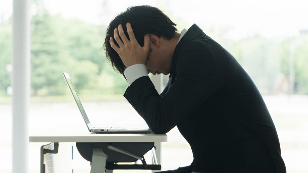 頭をかかえる男性