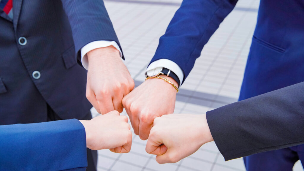 4人のビジネスマンがグータッチ